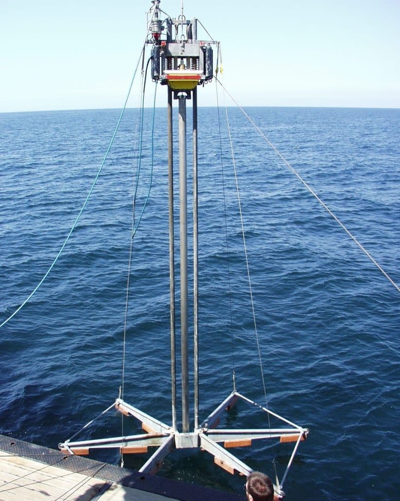 Vibro core drill rig suspended above the ocean off the deck of a survey vessel, ready to collect continuous sediment samples from the seafloor